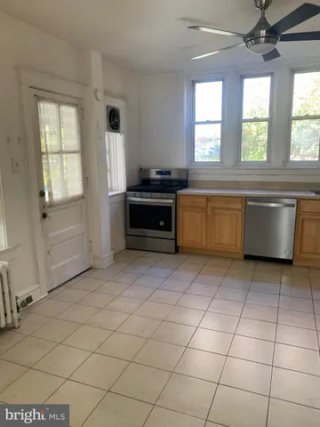 a large kitchen with a stove a sink dishwasher and a refrigerator