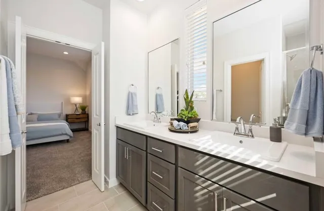 a en suite bathroom with a granite countertop sink and a mirror