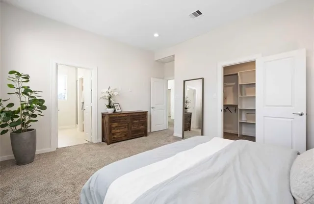a bedroom with a bed and a potted plant