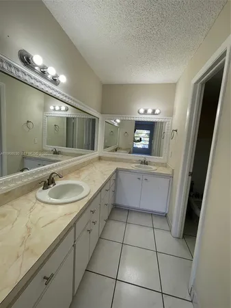 a large bathroom with a sink a toilet a mirror and a tub