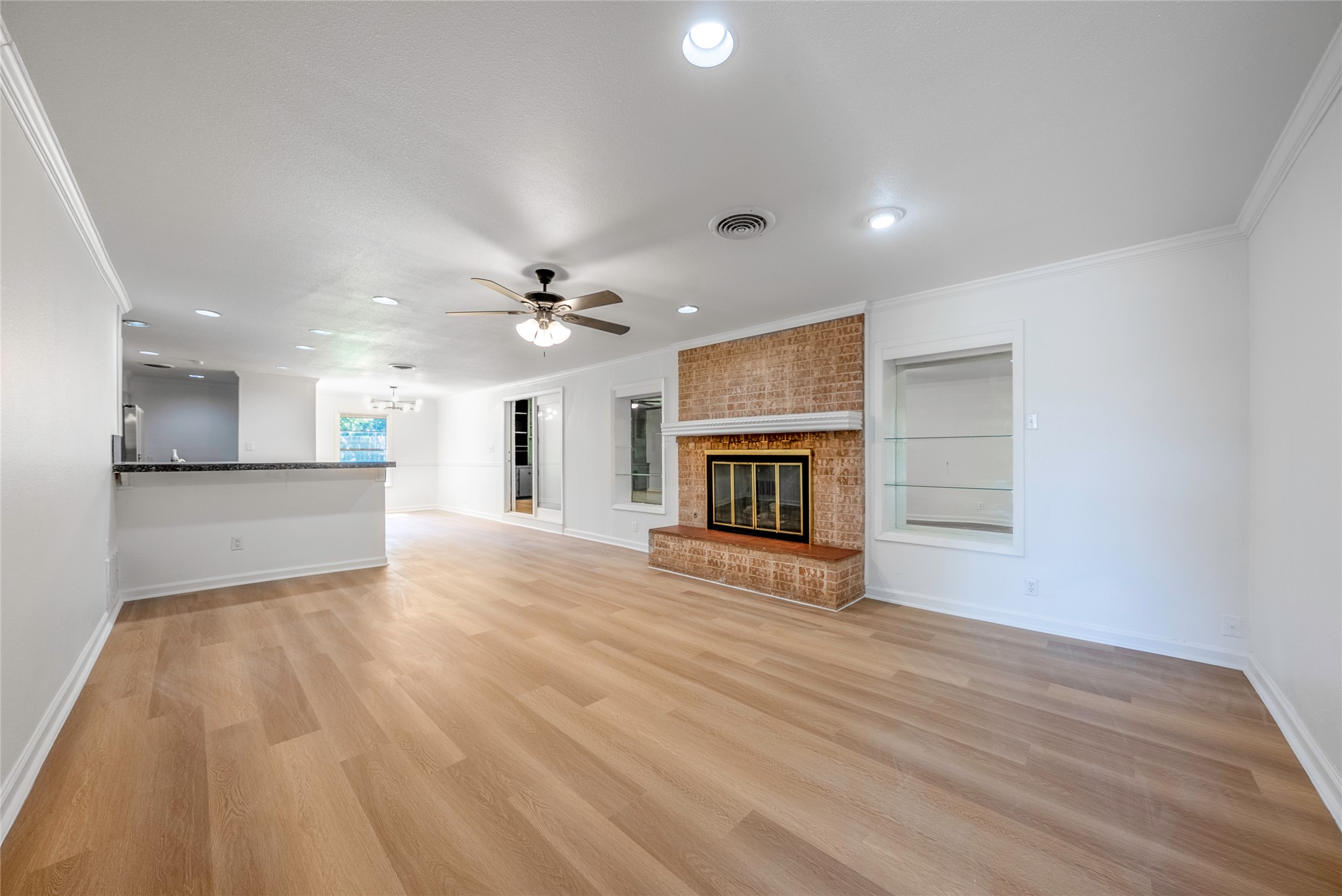 807 Country Club Road Georgetown, TX 78628 - Photo 4 of 28 a view of an empty room with wooden floor and a kitchen