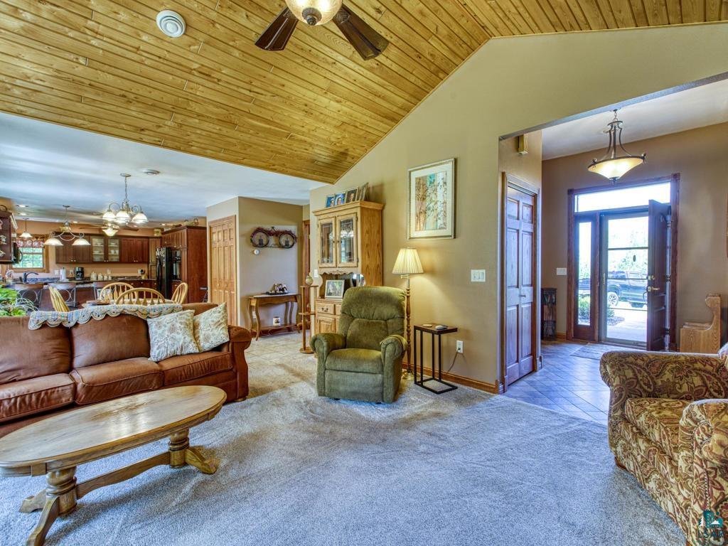 4678 Ridgeview Drive Superior, WI 54880 - Photo 12 of 43 Tiled living room featuring ceiling fan with notable chandelier, vaulted ceiling, and wood ceiling