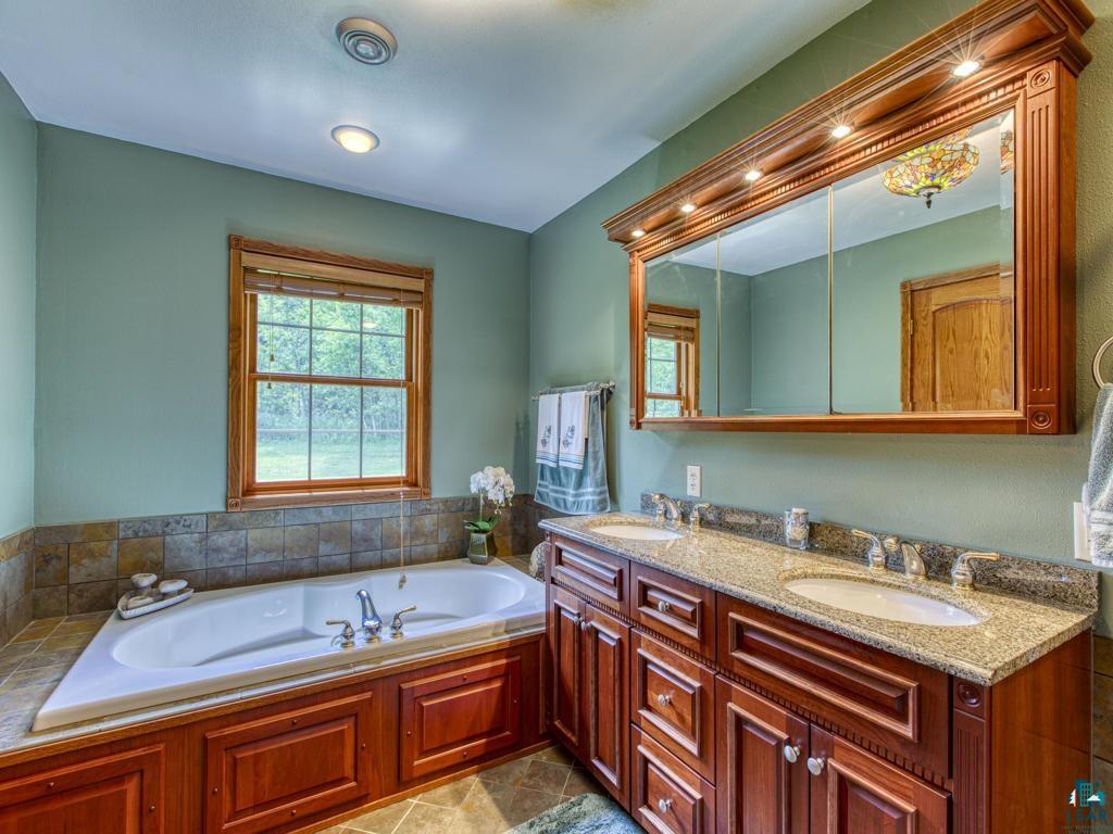 4678 Ridgeview Drive Superior, WI 54880 - Photo 20 of 43 Bathroom with dual vanity, tile patterned floors, and a tub