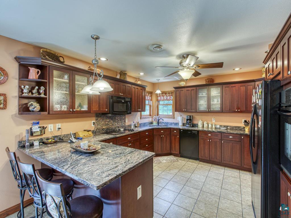 4678 Ridgeview Drive Superior, WI 54880 - Photo 2 of 43 Kitchen with black appliances, kitchen peninsula, decorative light fixtures, light tile patterned floors, and ceiling fan