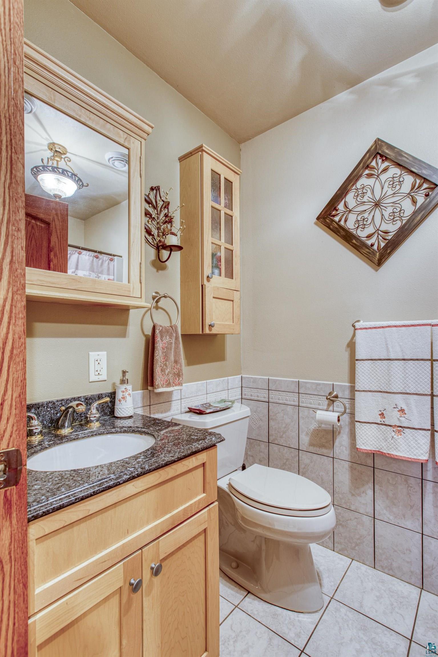 4678 Ridgeview Drive Superior, WI 54880 - Photo 23 of 43 Bathroom featuring tile patterned floors, vanity, tile walls, and toilet