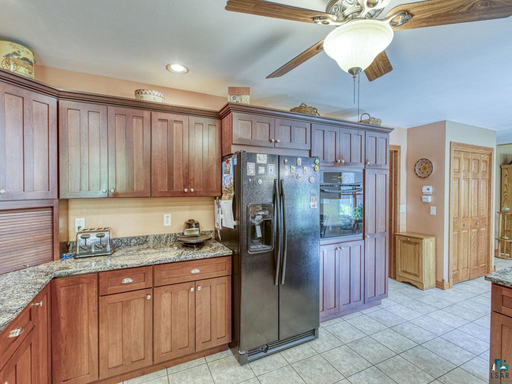 4678 Ridgeview Drive Superior, WI 54880 - Photo 5 of 43 Kitchen with light tile patterned flooring, light stone counters, ceiling fan, and black appliances