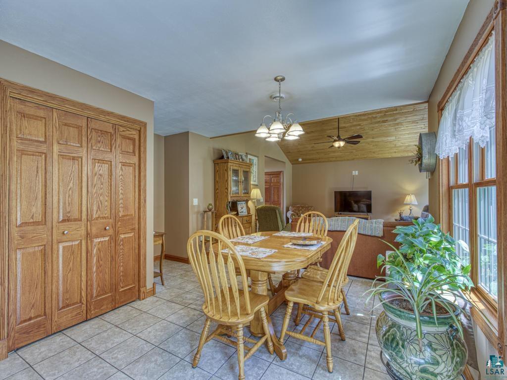 4678 Ridgeview Drive Superior, WI 54880 - Photo 7 of 43 Dining room with light tile patterned flooring, ceiling fan with notable chandelier, and vaulted ceiling