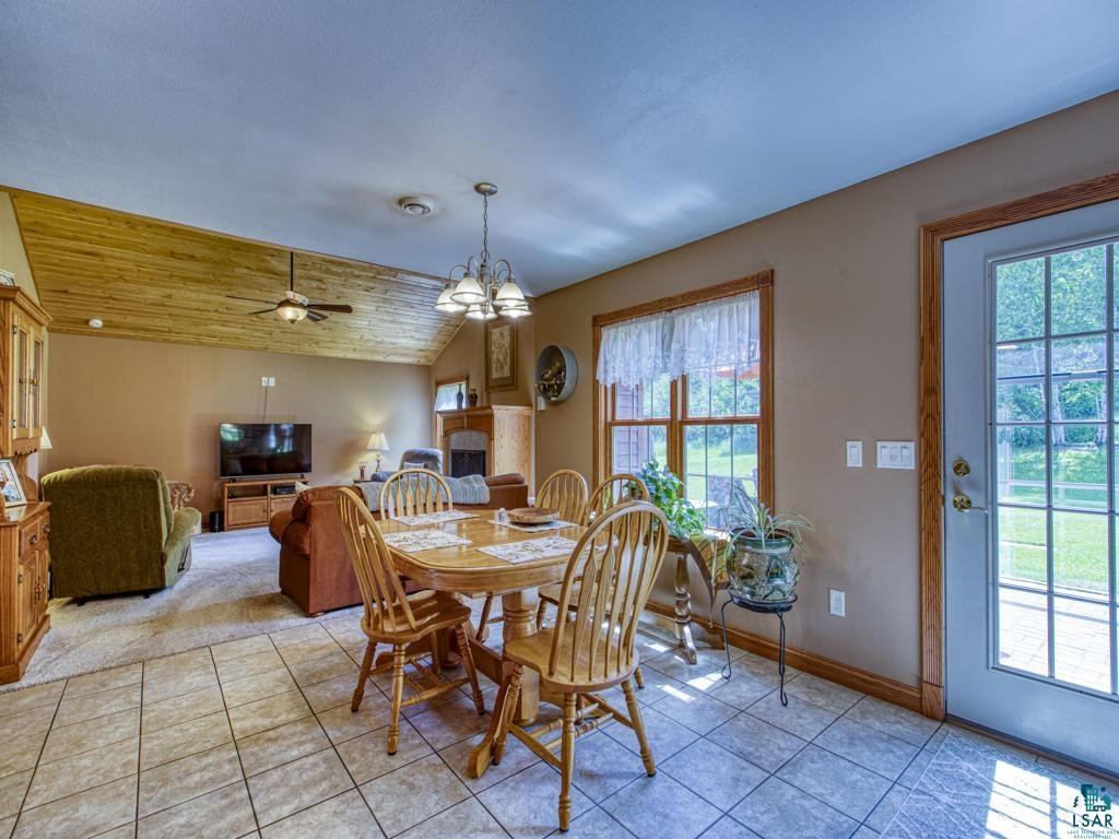 4678 Ridgeview Drive Superior, WI 54880 - Photo 8 of 43 Dining space featuring light tile patterned flooring, lofted ceiling, ceiling fan with notable chandelier, and wooden ceiling