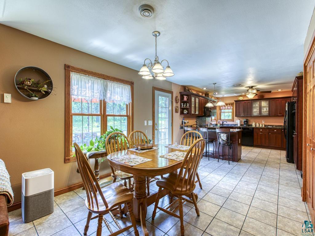 4678 Ridgeview Drive Superior, WI 54880 - Photo 9 of 43 Tiled dining room with ceiling fan with notable chandelier and plenty of natural light