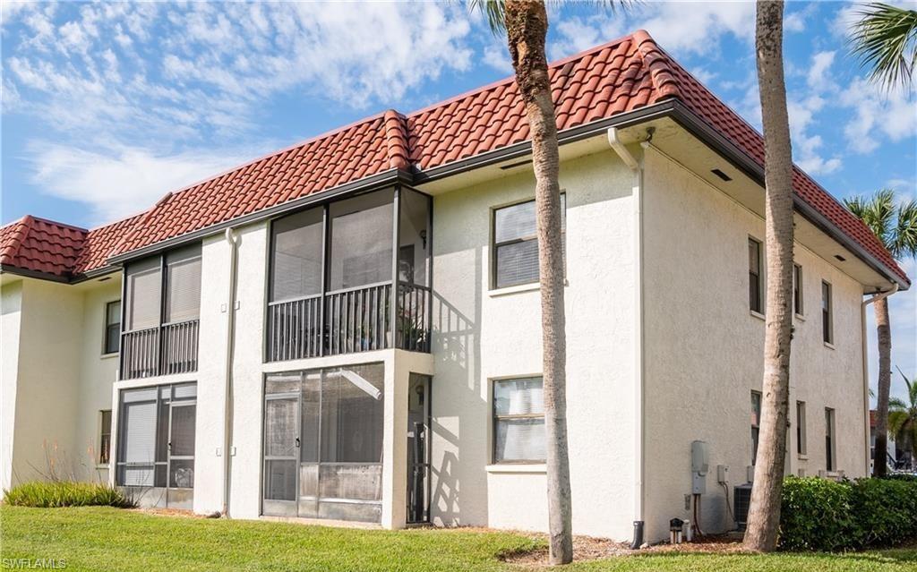 4346 27th Court Southwest, Unit 5 Naples, FL 34116 - Photo 2 of 18 a front view of a house with a garden