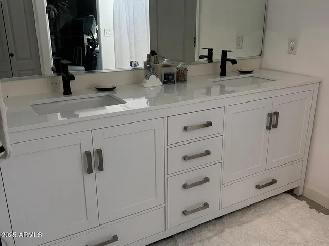 a bathroom with double vanity sink and mirror