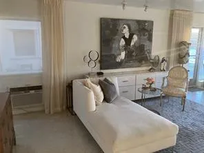 a dining room with furniture and a large window