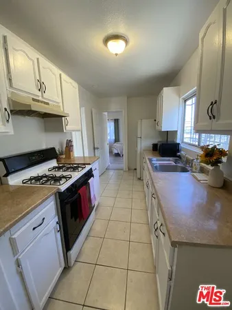 a kitchen with stainless steel appliances granite countertop a stove a sink dishwasher and cabinets with wooden floor