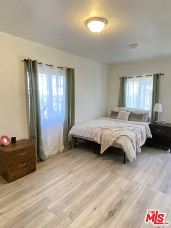 a spacious bedroom with a bed and a window