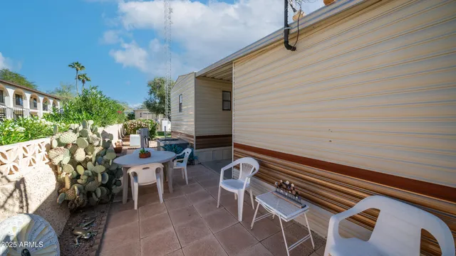 a view of a patio with wooden chairs