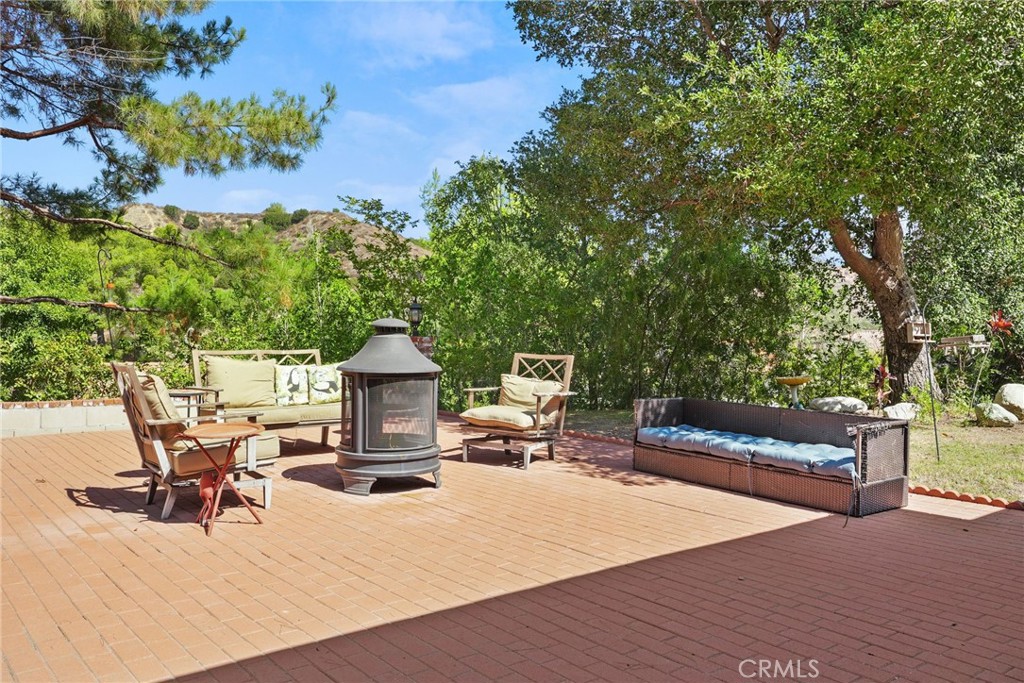 19317 Vista Grande Way Porter Ranch, CA 91326 - Photo 36 of 53 a view of a patio with dining table and chairs with a fire pit