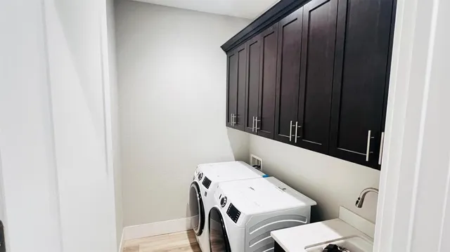 a bathroom with a toilet a sink and wooden floor