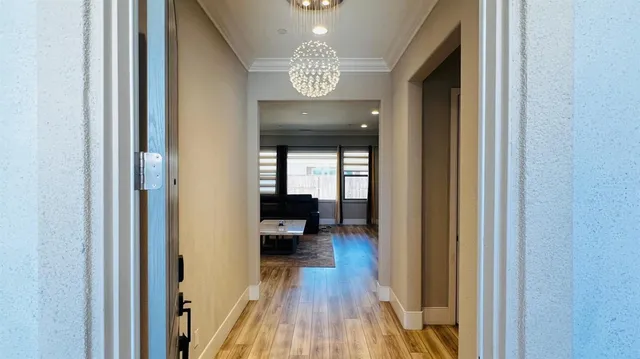 a view of a hallway with wooden floor and a livingroom