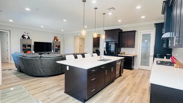 a large kitchen with stainless steel appliances kitchen island granite countertop a stove and a refrigerator