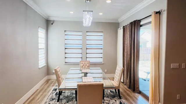a view of a dining room with furniture a chandelier and wooden floor