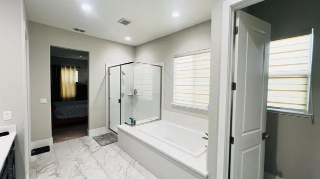 a bathroom with a tub shower and sink