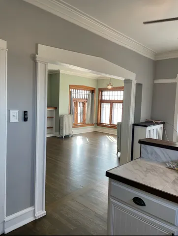 a view of a hallway with wooden floor and chandelier