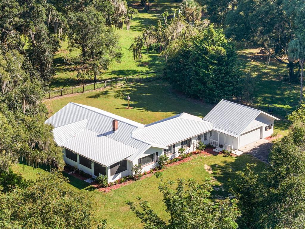 17067 Northwest Gainesville Road Reddick, FL 32686 - Photo 2 of 25 an aerial view of a house with swimming pool and lake view