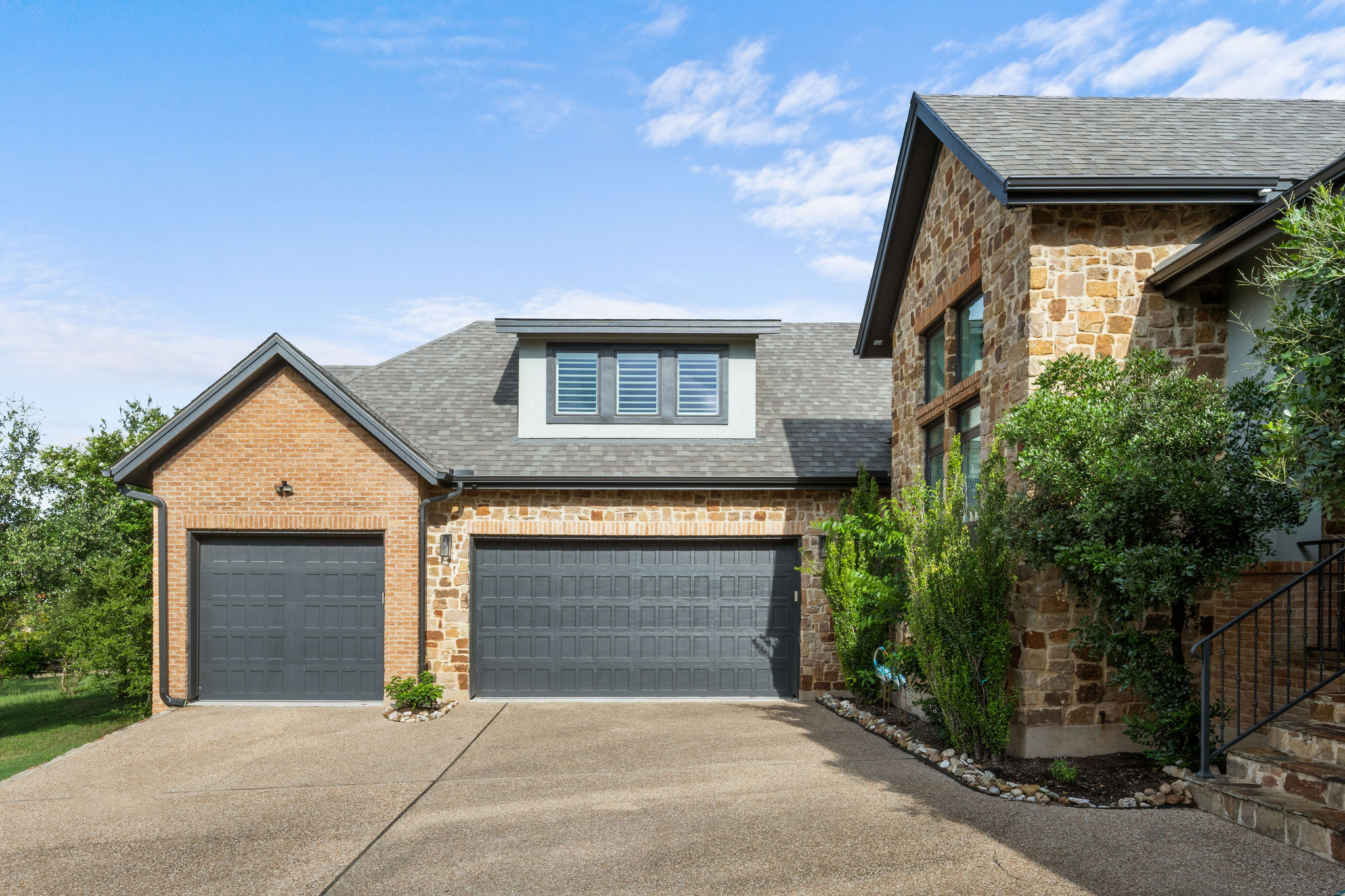 279 Rugged Earth Drive Austin, TX 78737 - Photo 3 of 39 A well-maintained residence boasts an inviting two-car garage and a meticulously landscaped facade.