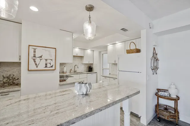 a bathroom with a granite countertop sink a toilet and a shower