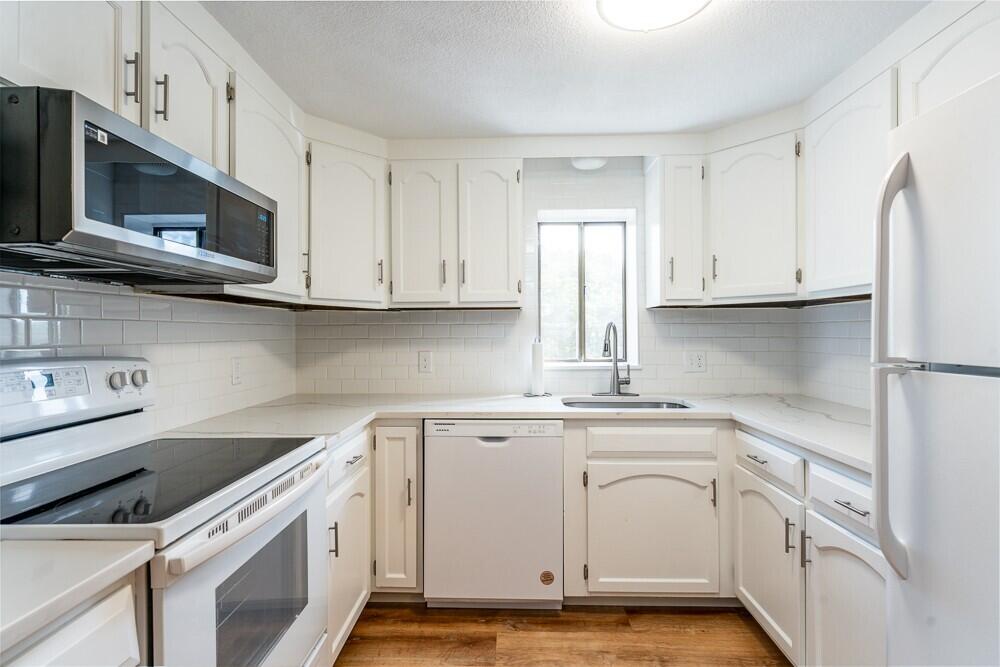825 West Main Street, Unit 4 Hyannis, MA 02601 - Photo 4 of 20 a view of a kitchen with white cabinets and stainless steel appliances