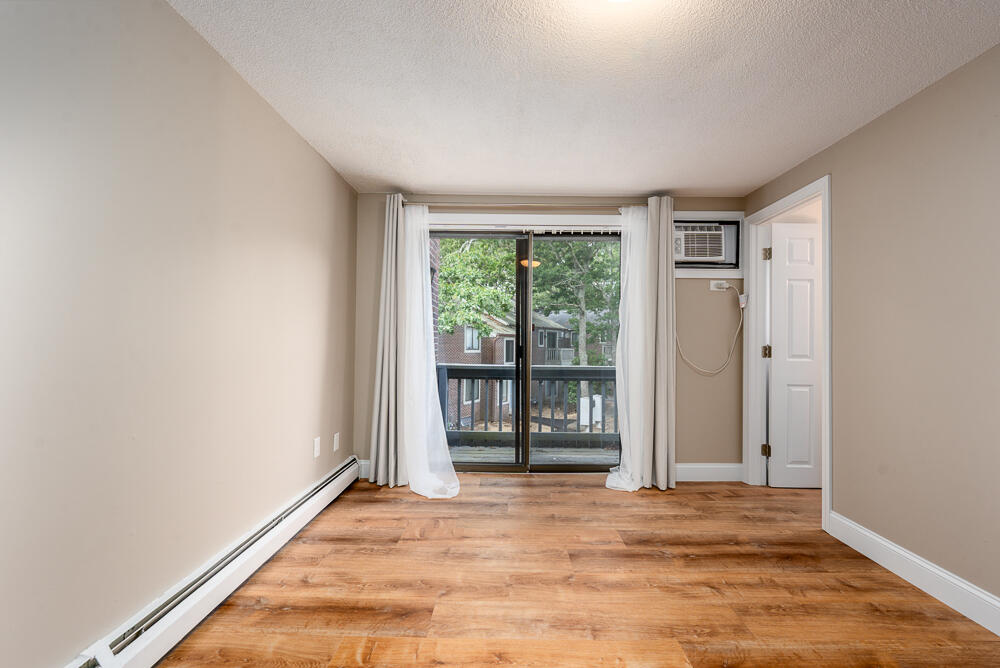 825 West Main Street, Unit 4 Hyannis, MA 02601 - Photo 7 of 20 an empty room with wooden floor and windows