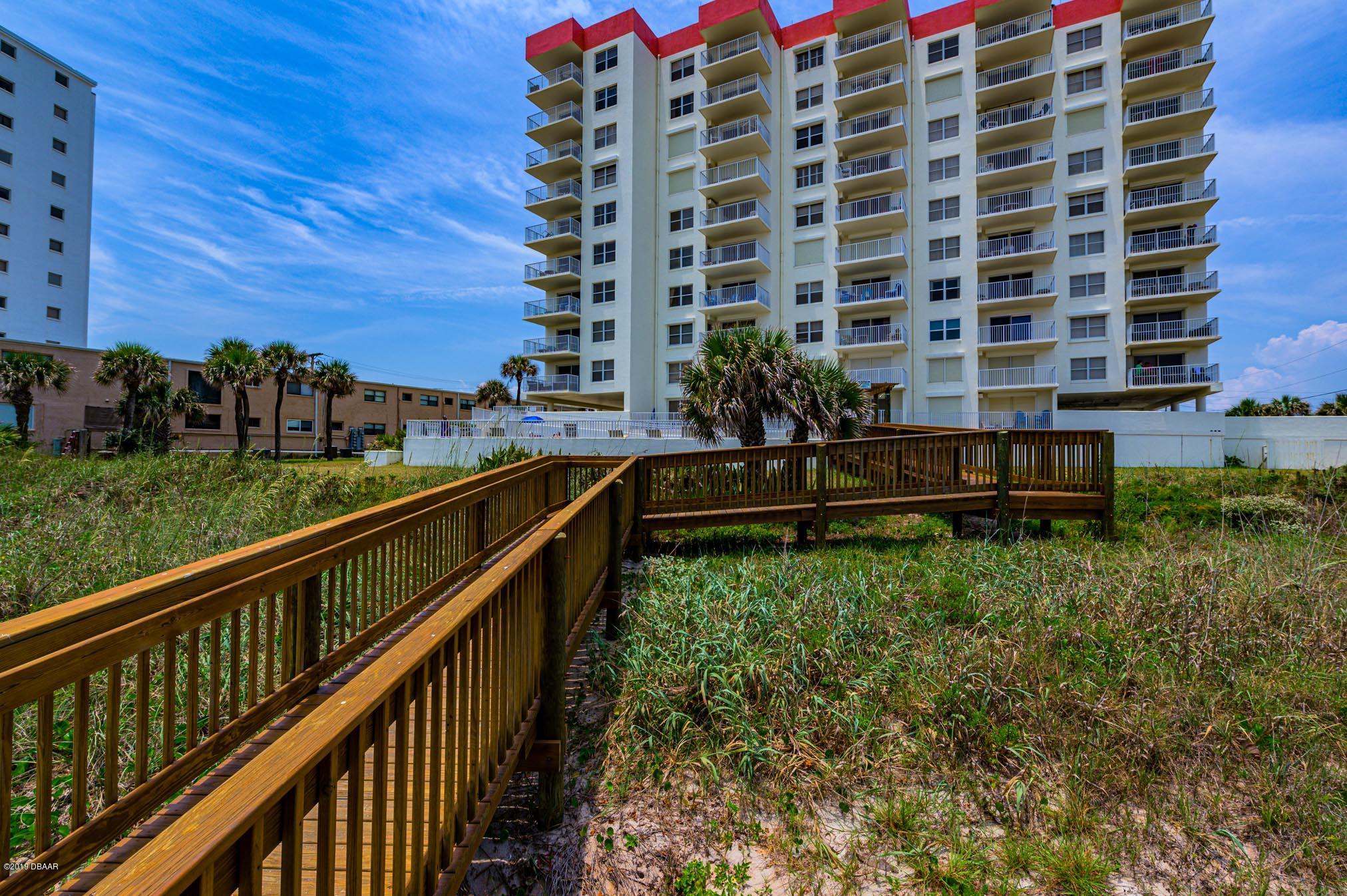 1183 Ocean Shore Boulevard, Unit 602 Ormond Beach, FL 32176 - Photo 24 of 27 a view of building with yard and staircase