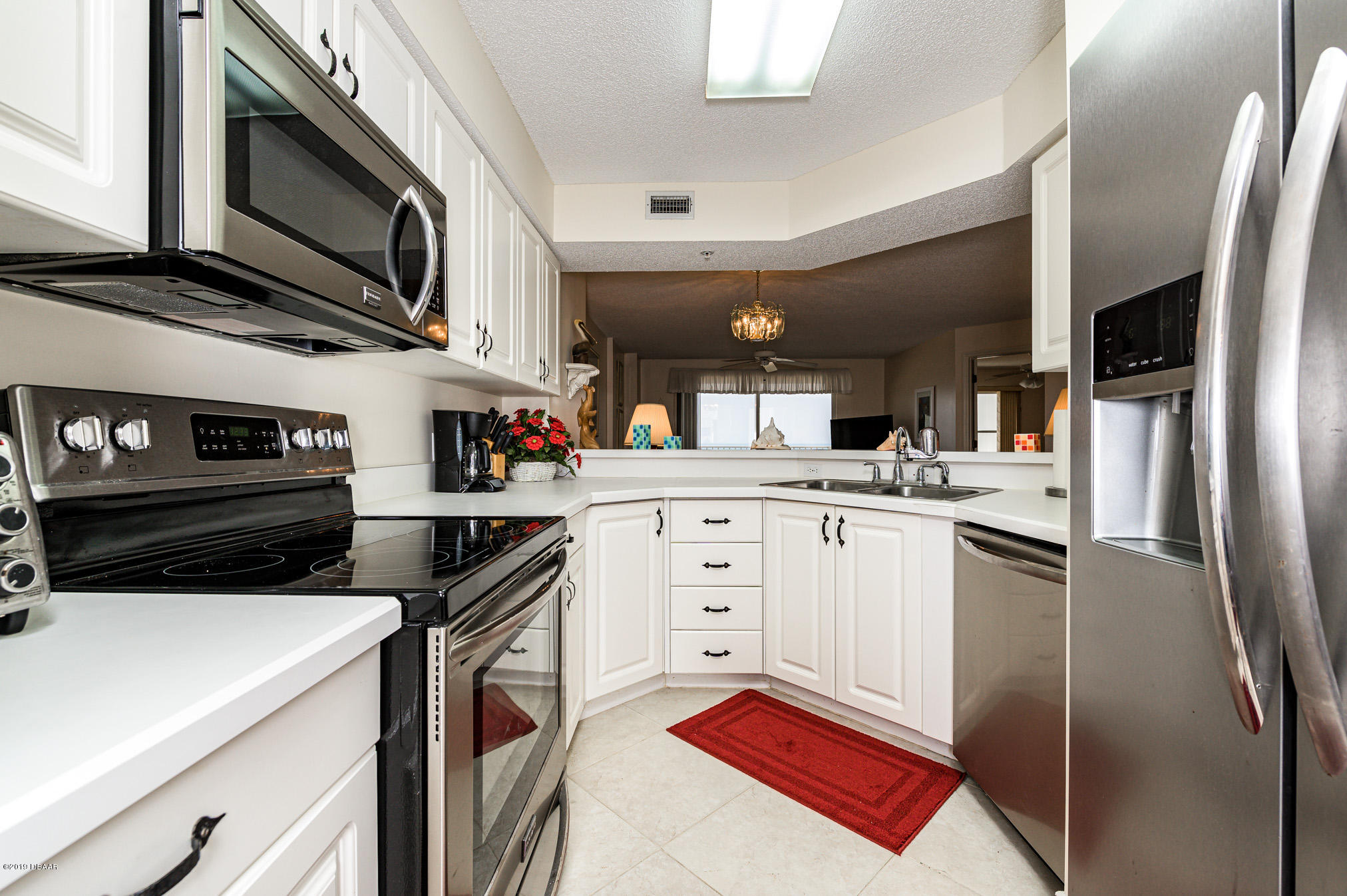 1183 Ocean Shore Boulevard, Unit 602 Ormond Beach, FL 32176 - Photo 5 of 27 a kitchen with cabinets stainless steel appliances and a counter space