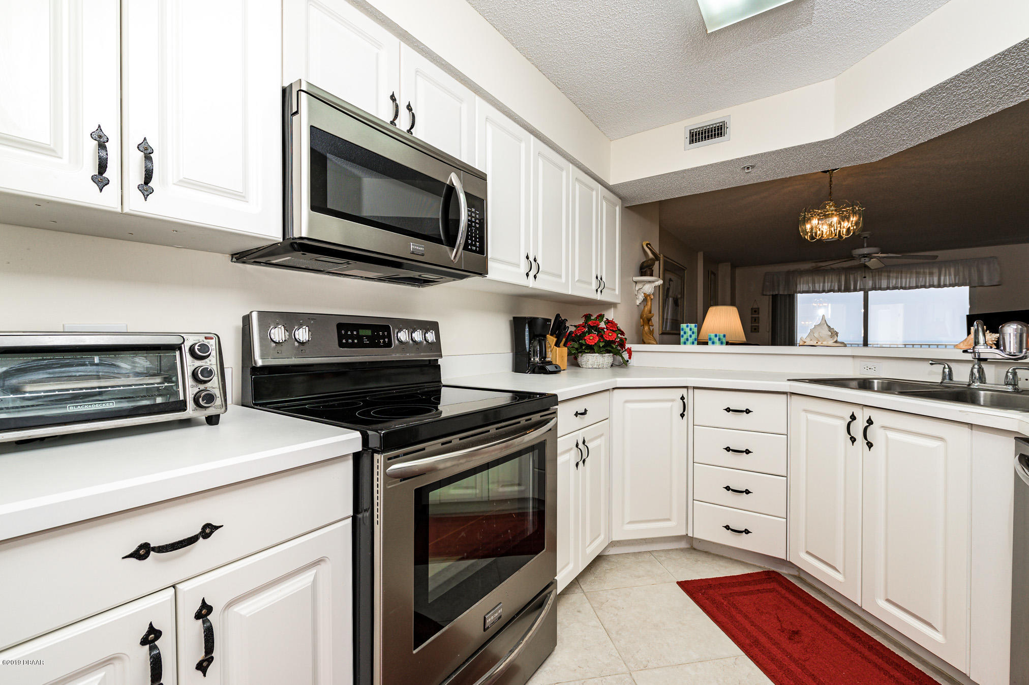 1183 Ocean Shore Boulevard, Unit 602 Ormond Beach, FL 32176 - Photo 6 of 27 a kitchen with cabinets stainless steel appliances and a counter space