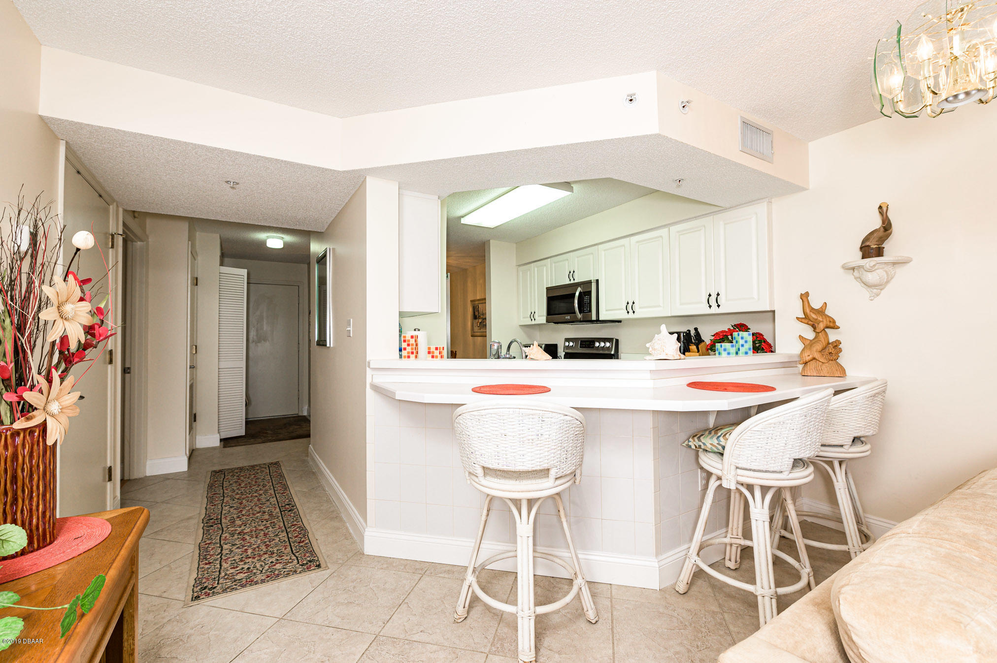 1183 Ocean Shore Boulevard, Unit 602 Ormond Beach, FL 32176 - Photo 9 of 27 a room with a table chairs and a kitchen view