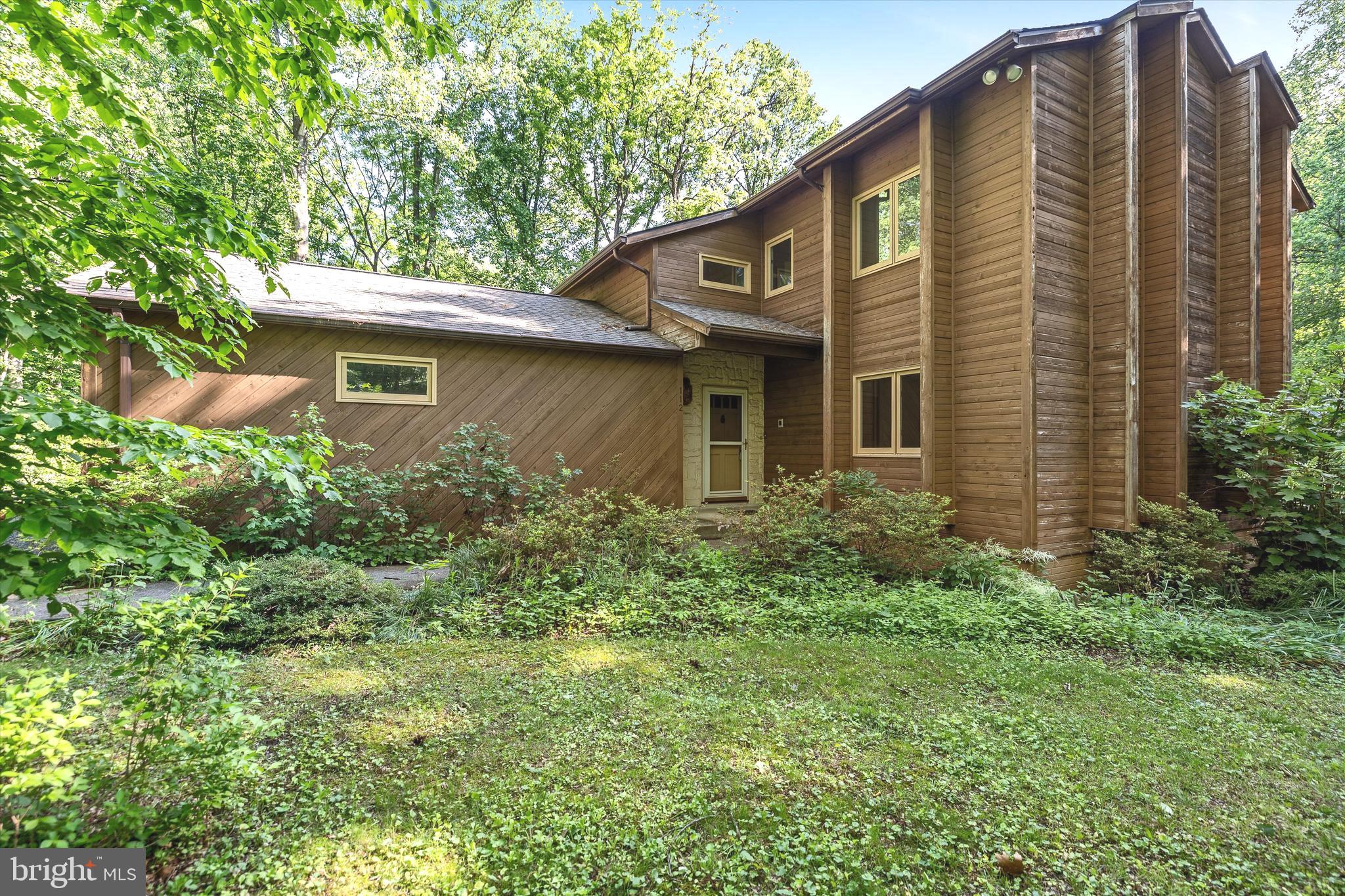 a front view of a house with plants and trees