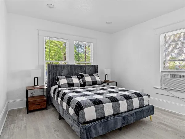 a bedroom with a bed lamp and a window