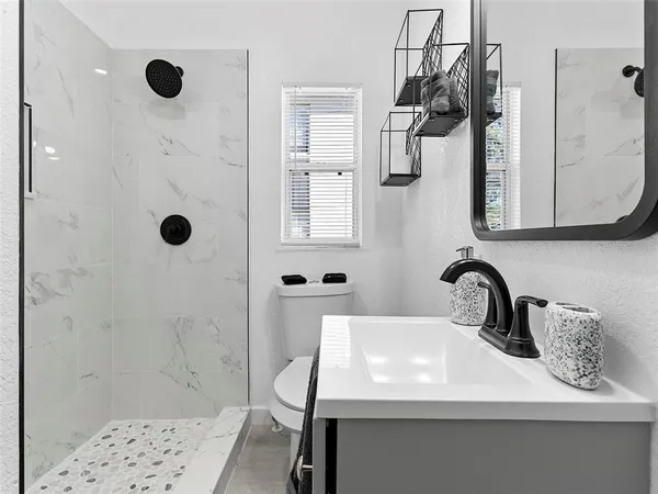 a bathroom with a sink a toilet and shower