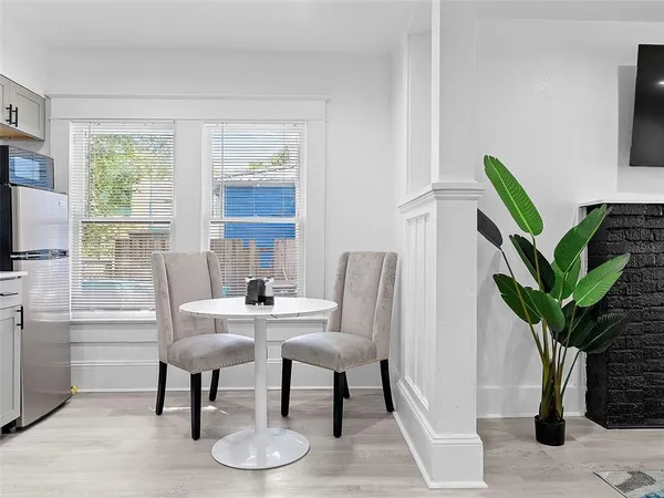a dining room with furniture and a potted plant