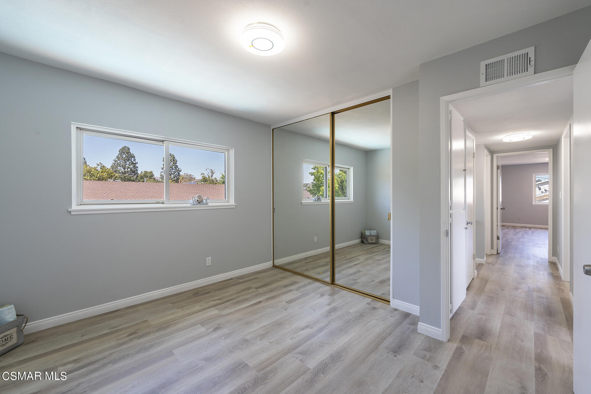 2305 Cochran Street Simi Valley, CA 93065 - Photo 23 of 43 an empty room with wooden floor and a way to kitchen