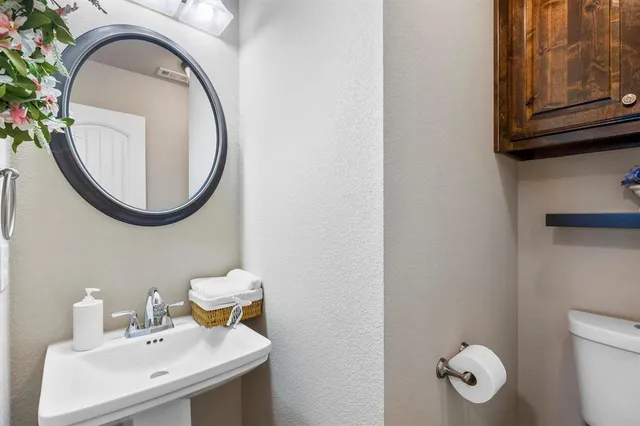 a bathroom with a toilet sink and mirror
