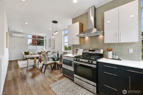 a kitchen with stainless steel appliances a stove a sink dishwasher and cabinets with wooden floor