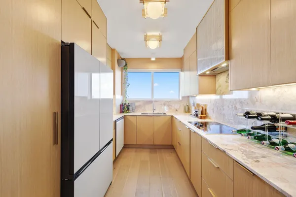 a kitchen with a sink a counter top space stainless steel appliances and cabinets