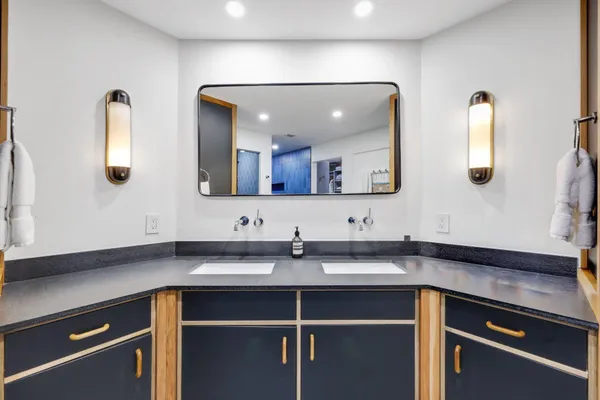 a kitchen with a sink and a stove top oven with wooden floor