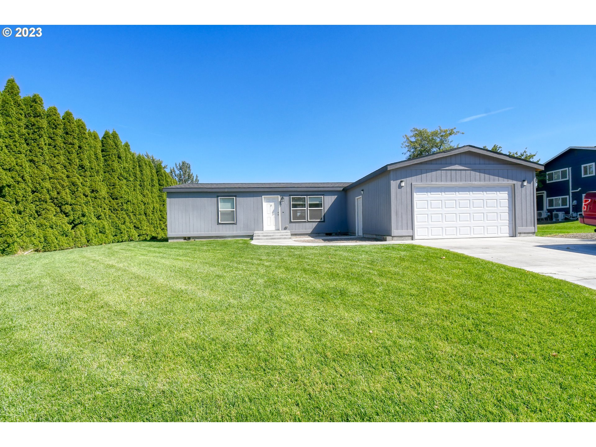 301 Northwest 3rd Street Boardman, OR 97818 - Photo 3 of 31 a front view of a house with a yard and garage