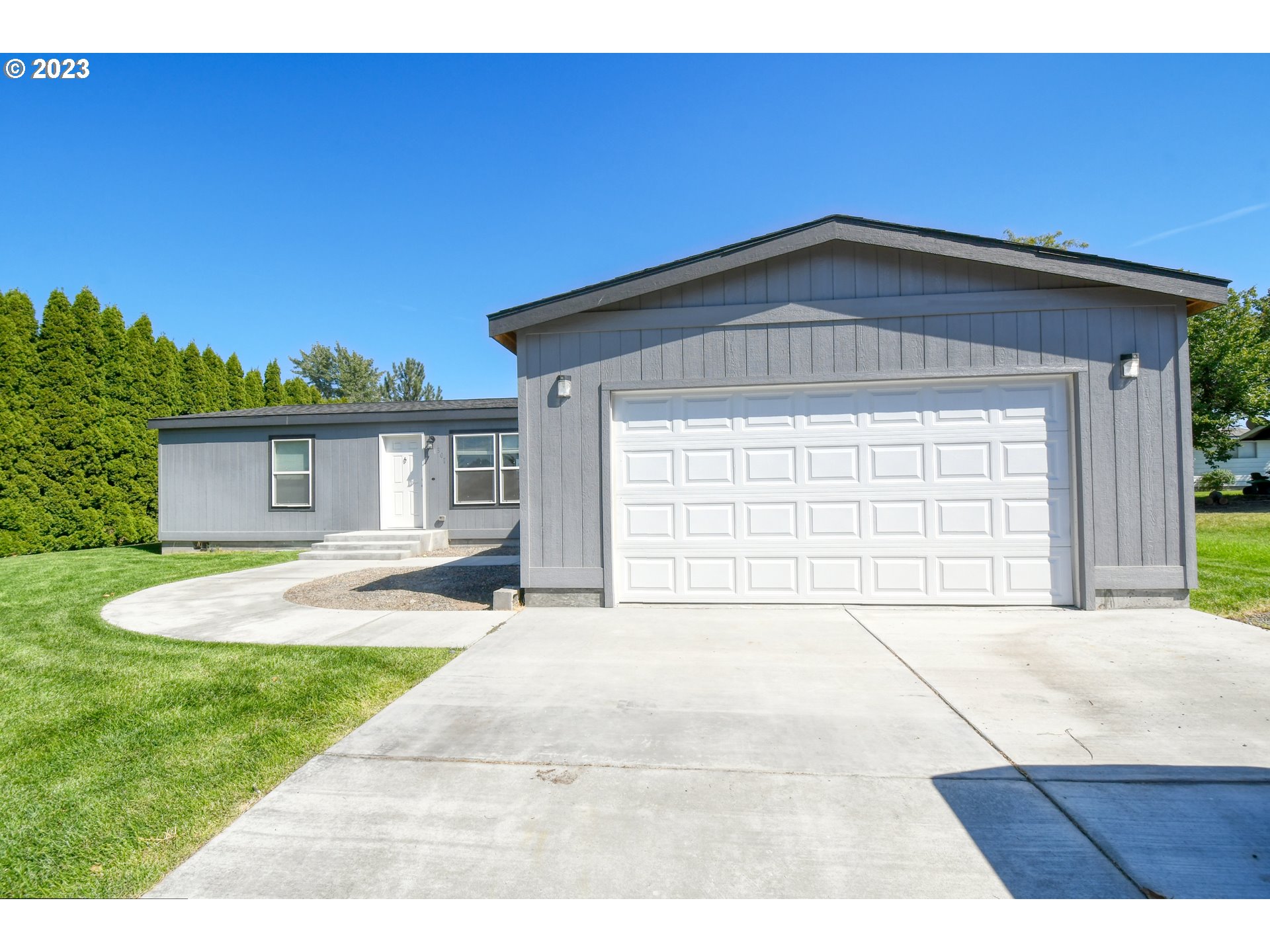 301 Northwest 3rd Street Boardman, OR 97818 - Photo 4 of 31 a front view of a house with a yard and garage