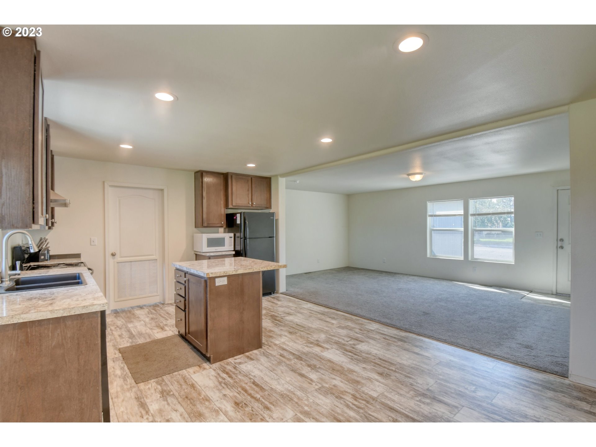 301 Northwest 3rd Street Boardman, OR 97818 - Photo 7 of 31 a kitchen with a stove a sink and a refrigerator