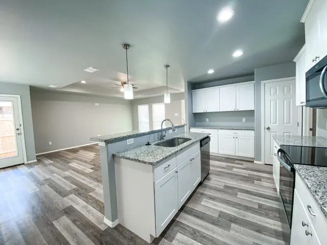 a kitchen with kitchen island a stove a sink and a refrigerator