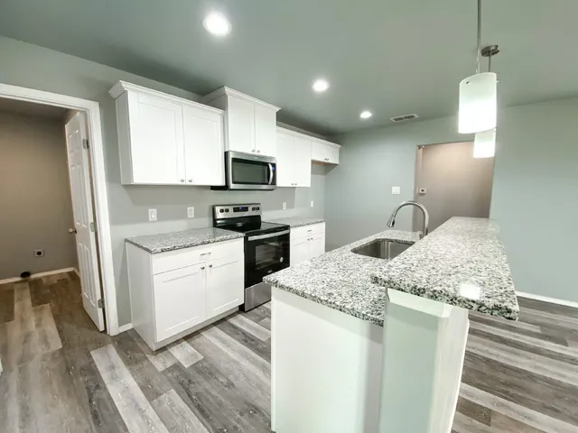 a kitchen with a sink stove and microwave