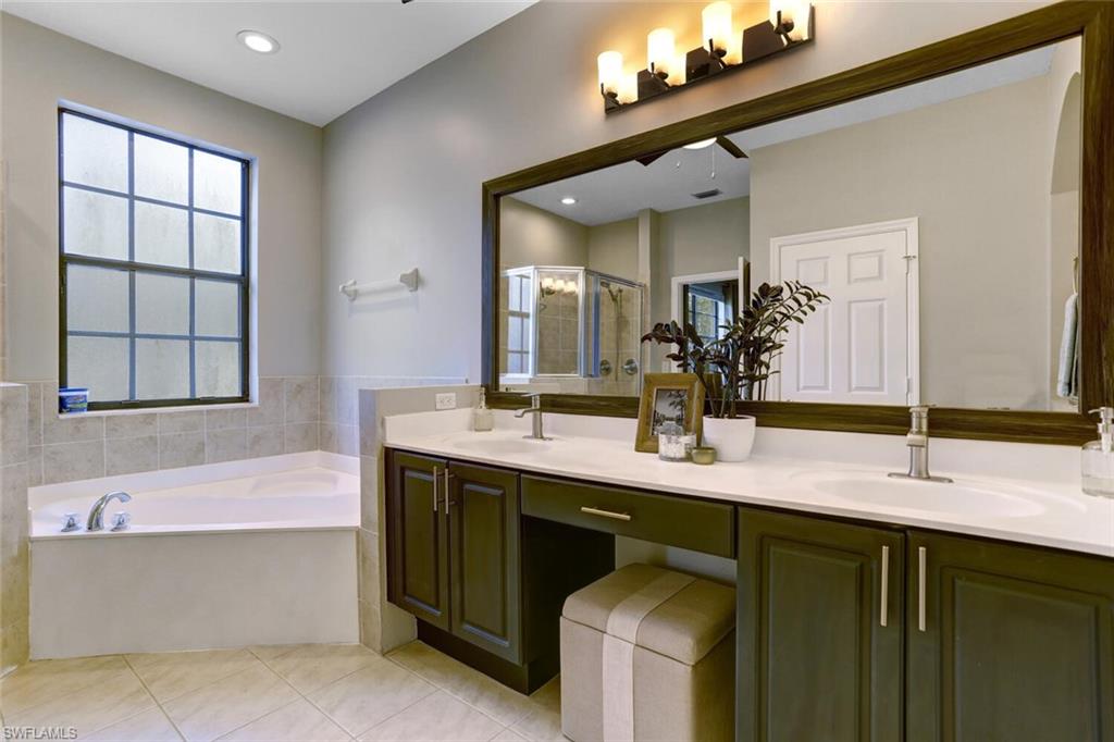 14966 Summit Pl Circle Naples, FL 34119 - Photo 4 of 14 a bathroom with a double vanity sink mirror and bathtub